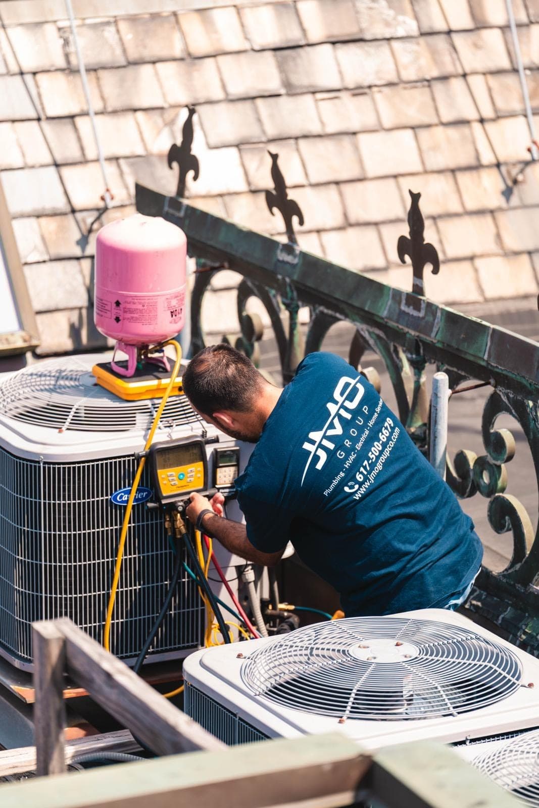 JMO technician servicing rooftop HVAC equipment with gauges and tools