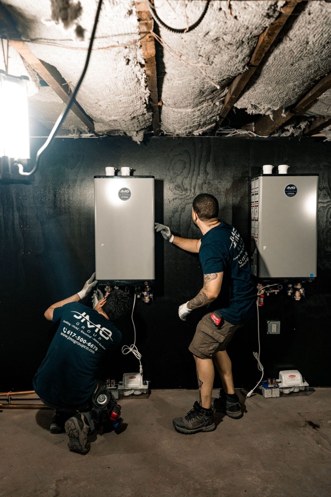 Two JMO technicians installing tankless water heaters