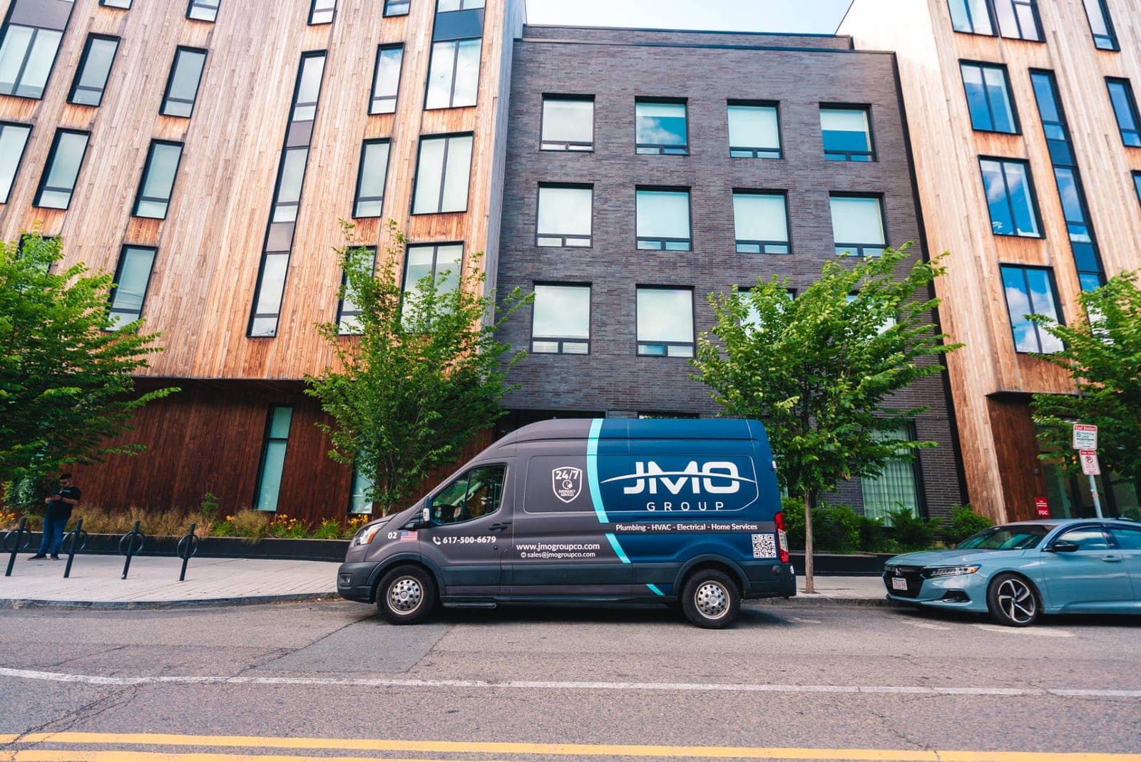 JMO Group service van parked outside a modern apartment building