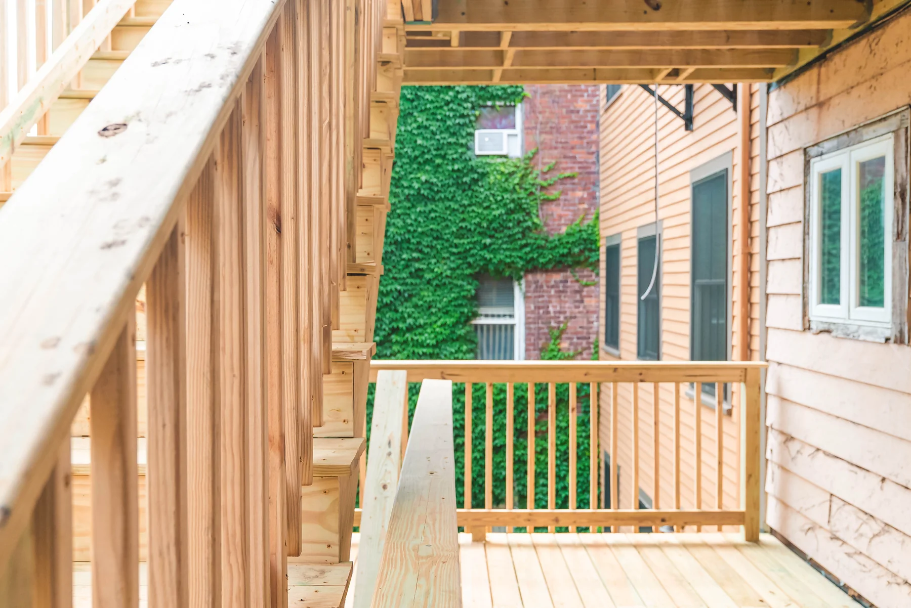 Timber porch, stairs, and railings alongside a residential building