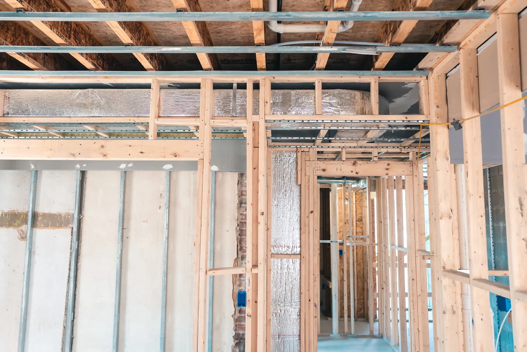 Interior framing, exposed brick, and ductwork during construction at 90 Revere Street