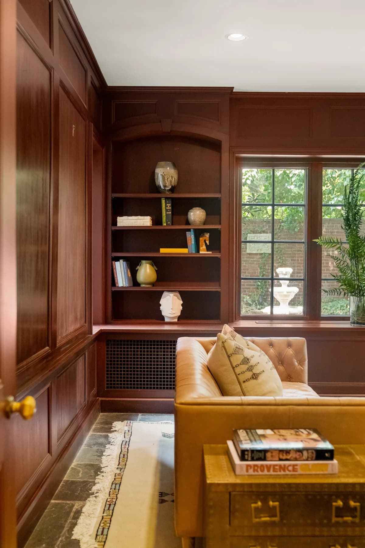 Wood-paneled study with fitted bookshelves and a tall window at 372 Warren Street