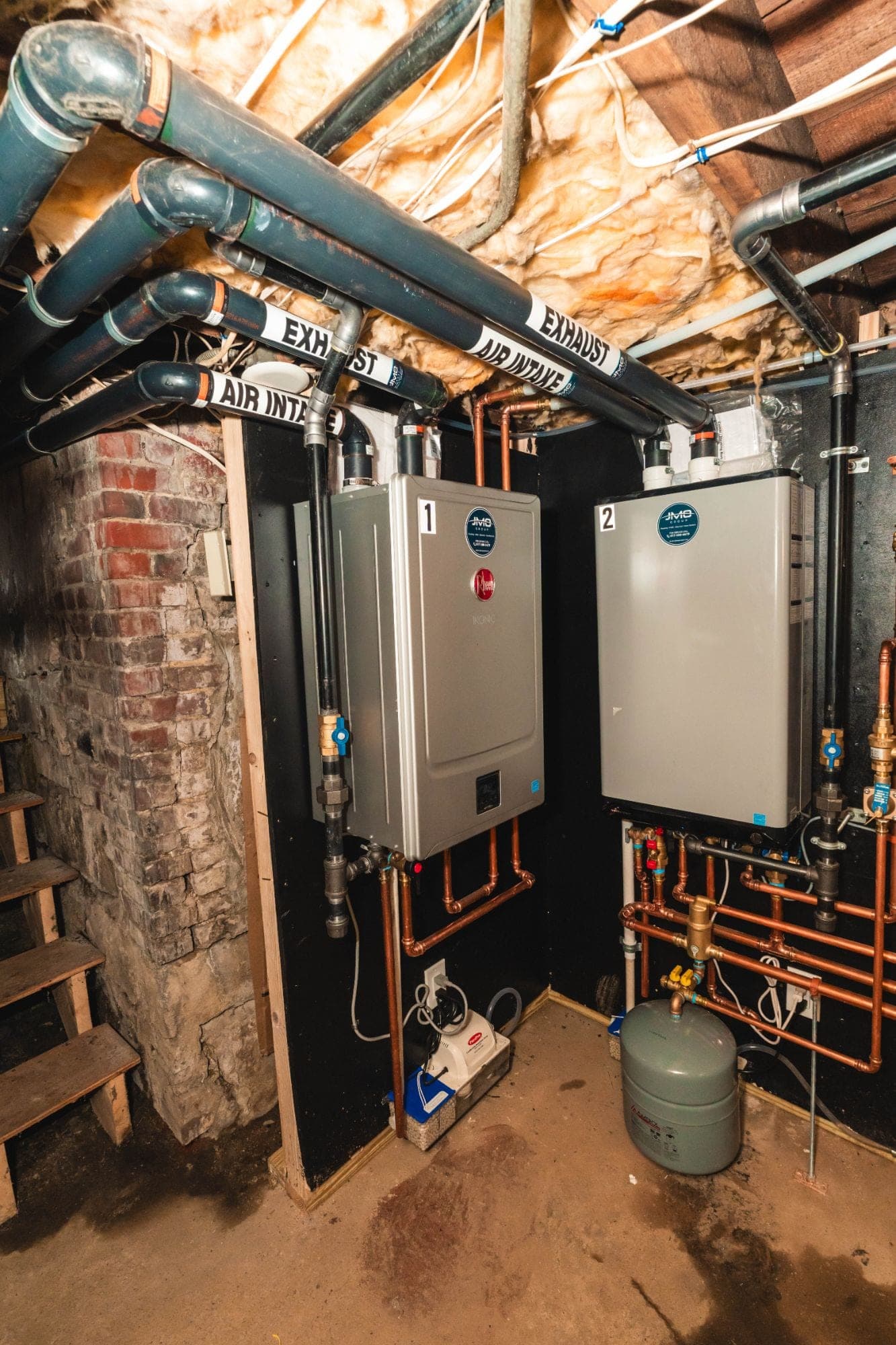 Two JMO-installed wall-hung boilers with labeled air intake and exhaust venting