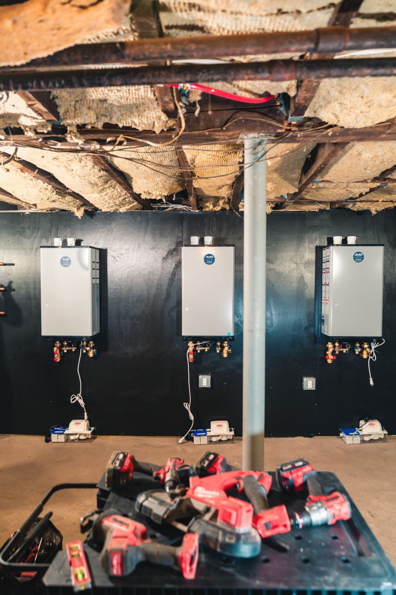 Three JMO-installed tankless water heaters in a building mechanical room