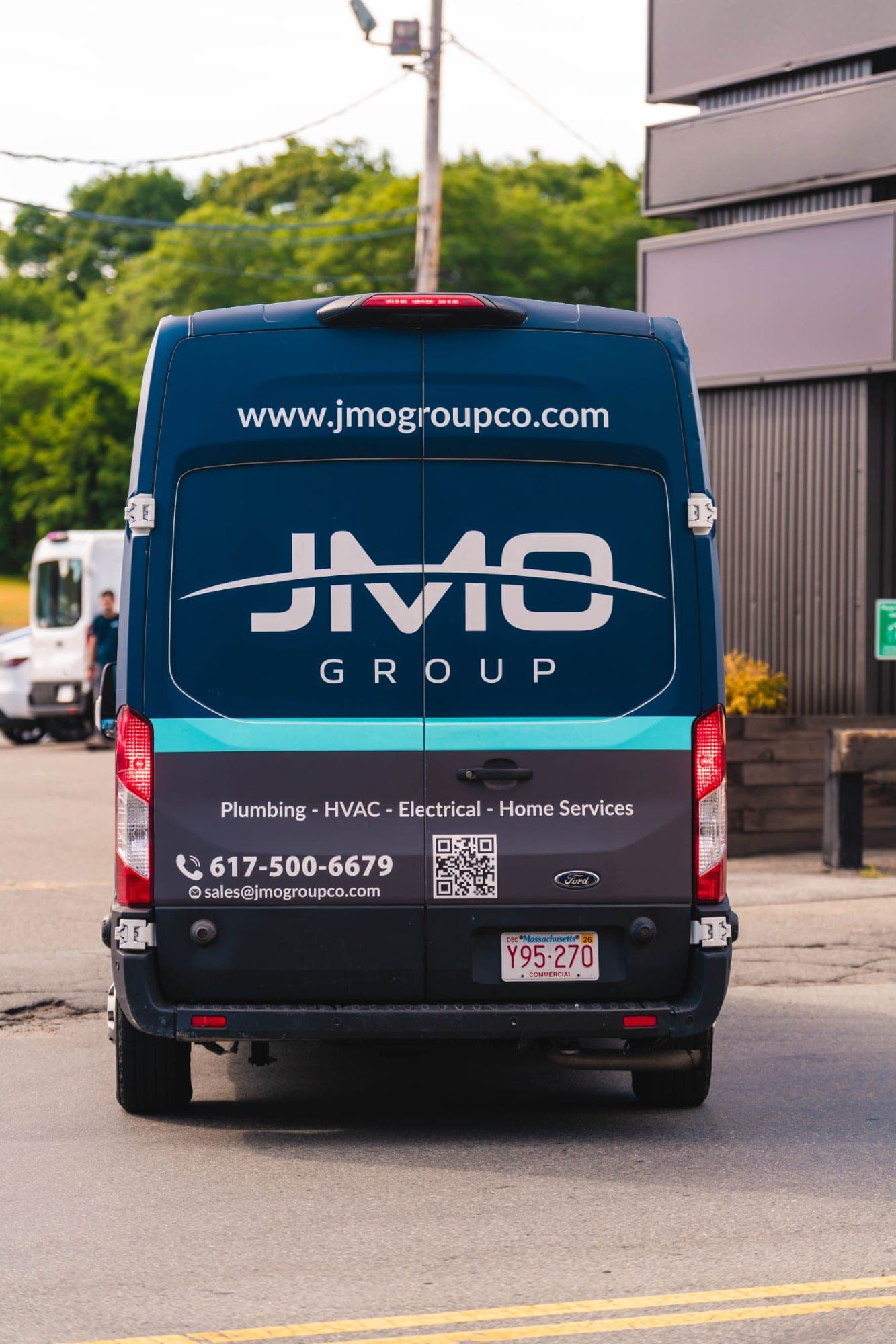 Rear of a JMO Group service van showing the company phone number and website